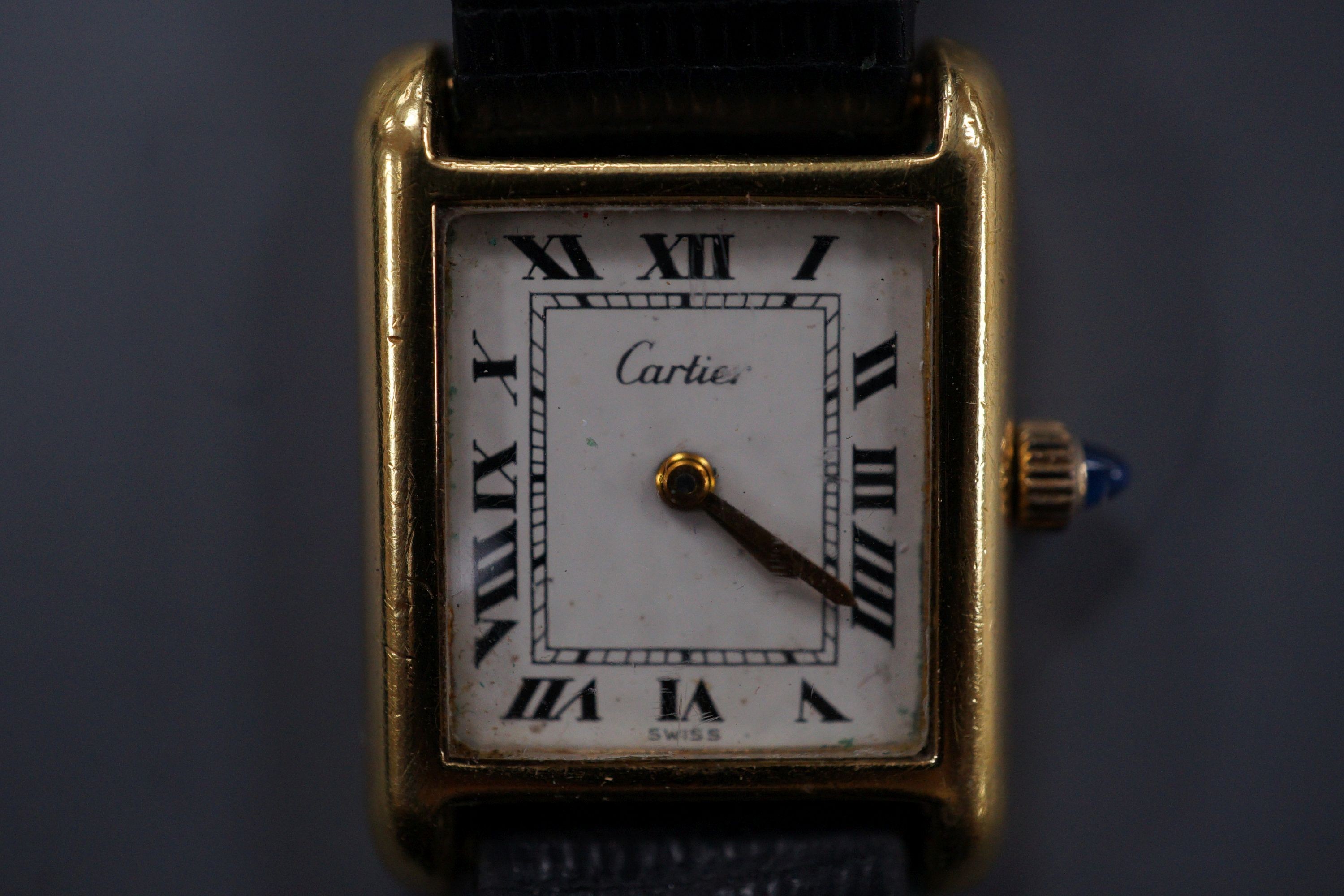 A ladies gold plated Cartier tank wrist watch, with cabochon set winder.